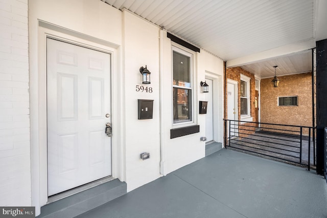 entrance to property with brick siding and covered porch