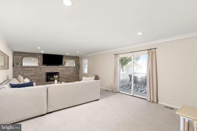 living area featuring a stone fireplace, crown molding, visible vents, and carpet floors