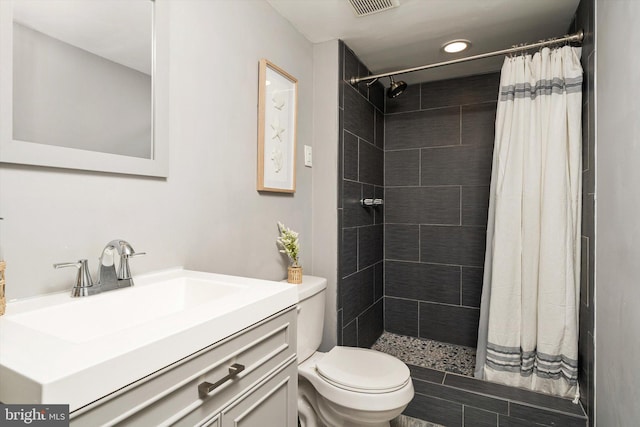 full bathroom with toilet, a stall shower, and vanity