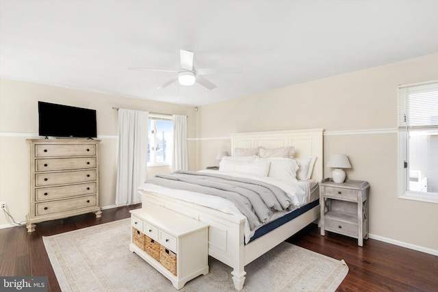 bedroom with multiple windows, baseboards, and wood finished floors