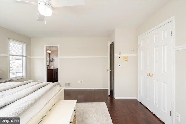 bedroom featuring visible vents, dark wood-type flooring, ceiling fan, baseboards, and ensuite bathroom