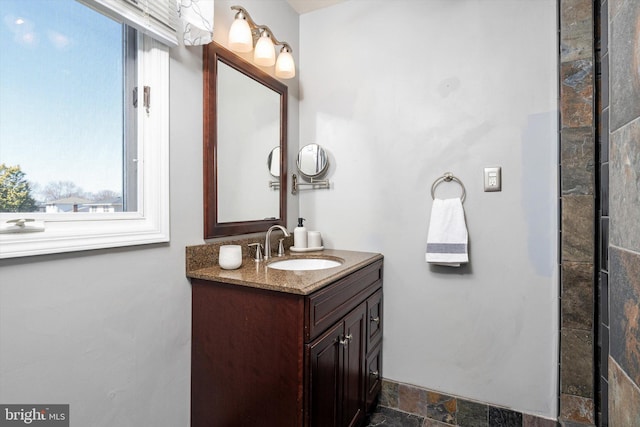 bathroom with stone tile floors and vanity