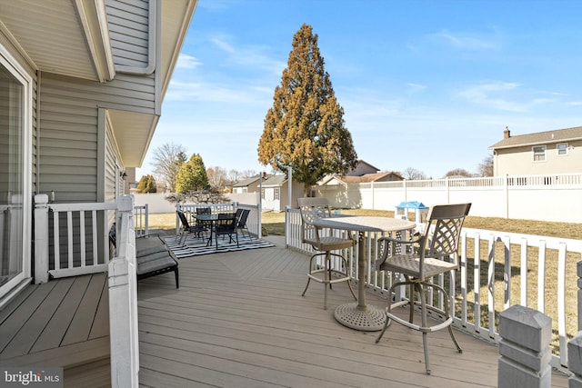 wooden deck with a fenced backyard, a residential view, and outdoor dining space