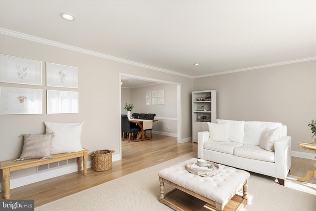 living room featuring recessed lighting, baseboards, light wood-style floors, and ornamental molding