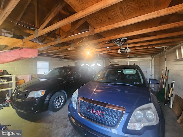 garage featuring concrete block wall and a garage door opener