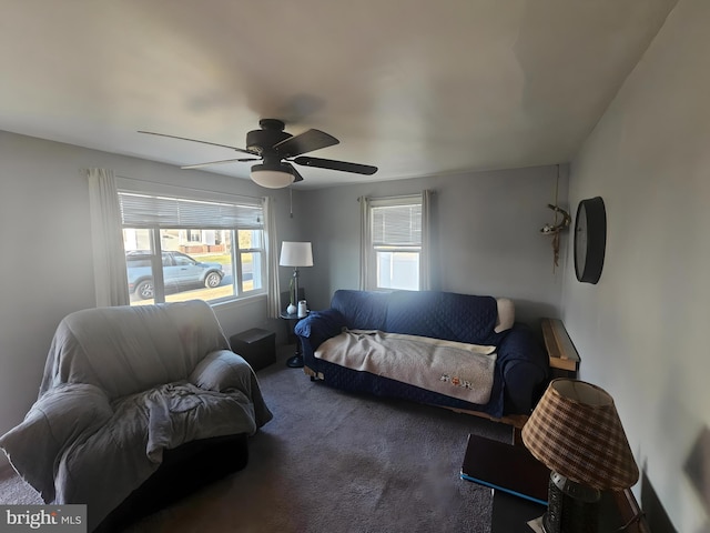 carpeted living area with ceiling fan