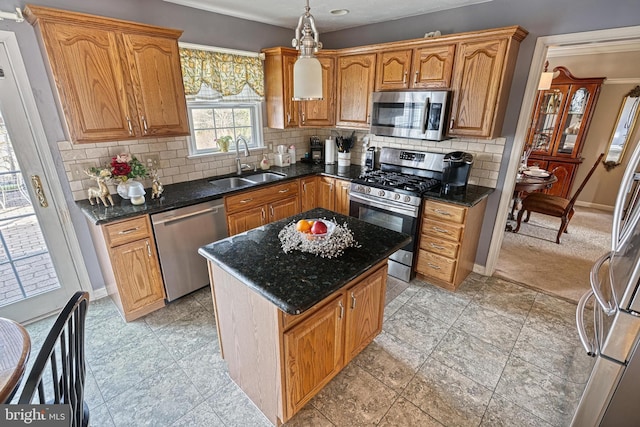 kitchen featuring a center island, baseboards, decorative backsplash, appliances with stainless steel finishes, and a sink