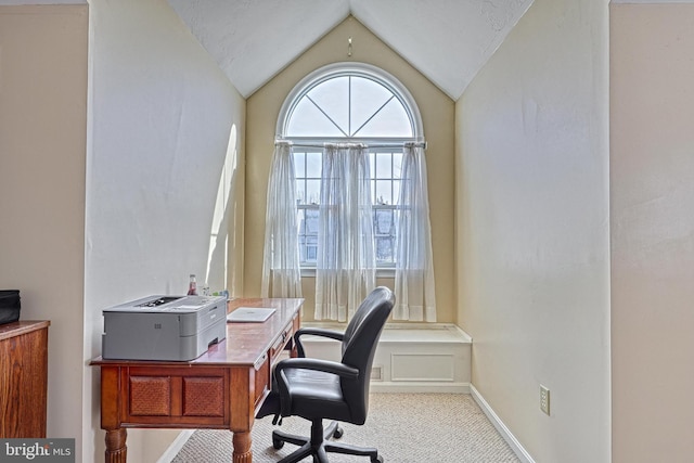 carpeted home office with baseboards and vaulted ceiling