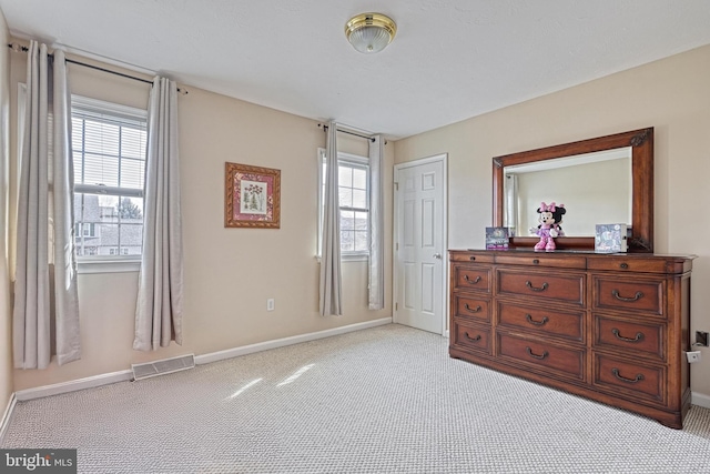 bedroom featuring visible vents, light colored carpet, baseboards, and multiple windows