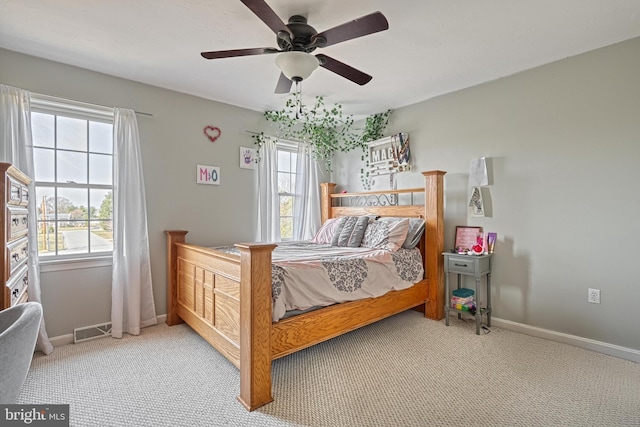 bedroom featuring a ceiling fan, multiple windows, baseboards, and visible vents