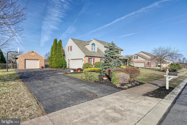 new england style home with aphalt driveway, a garage, fence, and brick siding