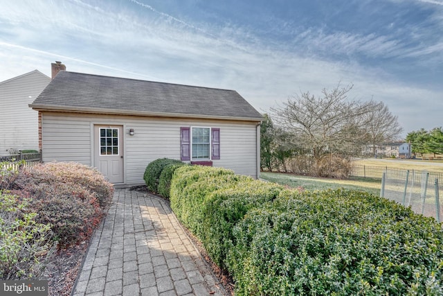 exterior space featuring a chimney and fence