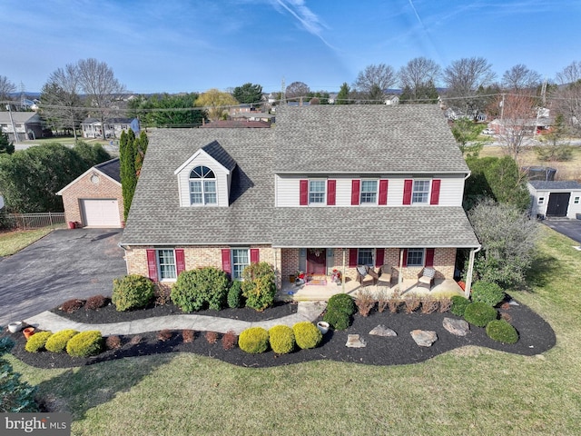 view of front of property featuring aphalt driveway, a garage, brick siding, and a shingled roof