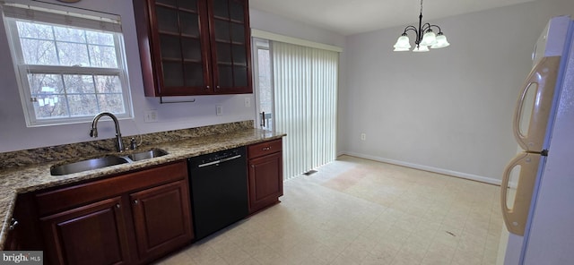 kitchen with a sink, freestanding refrigerator, glass insert cabinets, light floors, and dishwasher