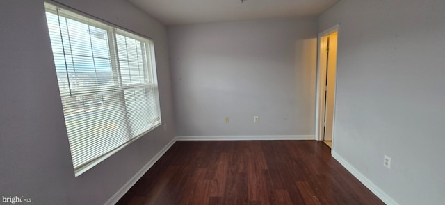 spare room featuring wood finished floors and baseboards