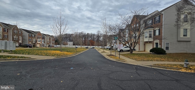 view of street with sidewalks, a residential view, and curbs