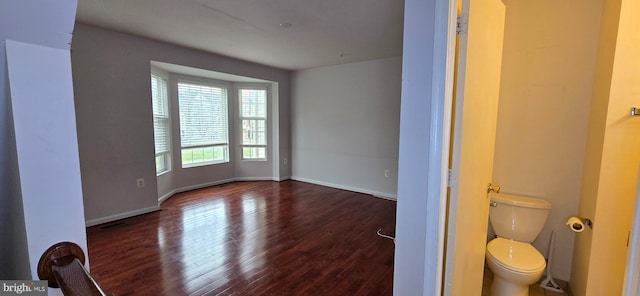 bathroom with visible vents, baseboards, toilet, and wood finished floors