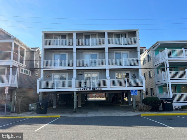 view of building exterior featuring central AC unit and uncovered parking