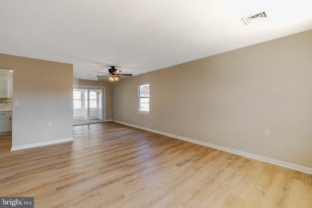 empty room featuring ceiling fan, visible vents, baseboards, and light wood-style flooring