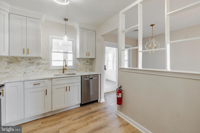 kitchen featuring a sink, stainless steel dishwasher, white cabinets, light wood finished floors, and decorative backsplash