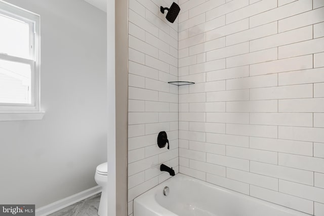 bathroom with toilet, baseboards, and shower / bath combination