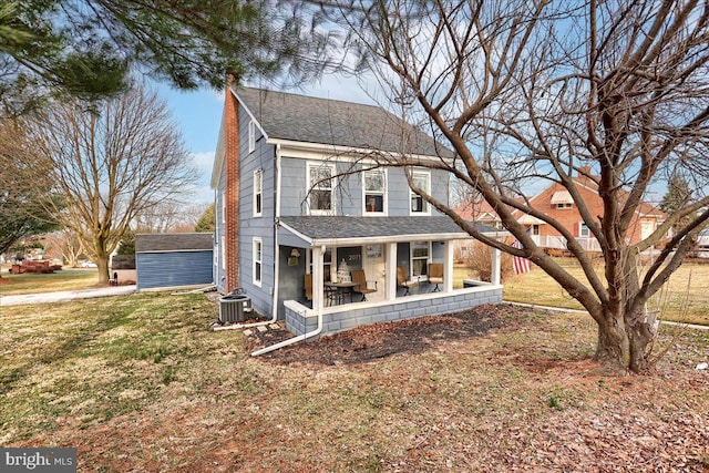 view of front of property featuring an outbuilding, a front yard, a shingled roof, central AC unit, and a chimney