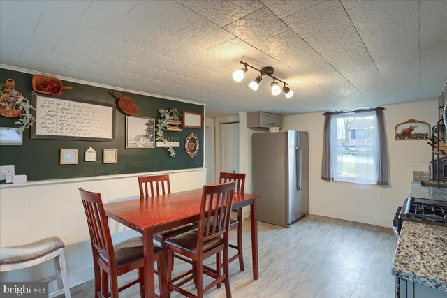 dining space with light floors and baseboards