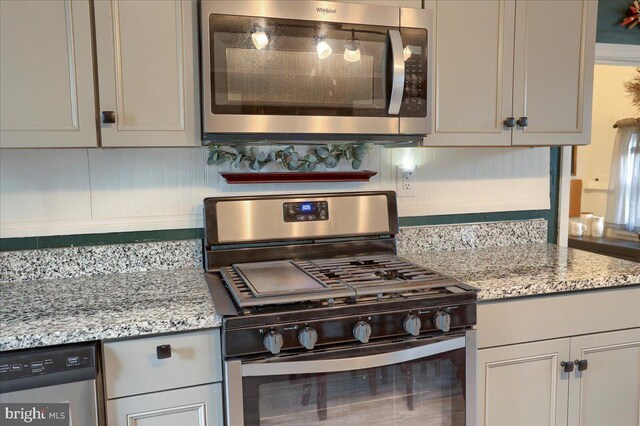 kitchen with decorative backsplash, appliances with stainless steel finishes, and light stone countertops