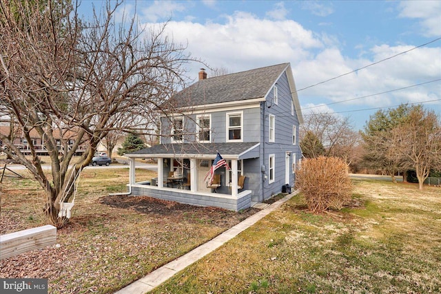 view of front facade with covered porch, a chimney, a front lawn, and a shingled roof