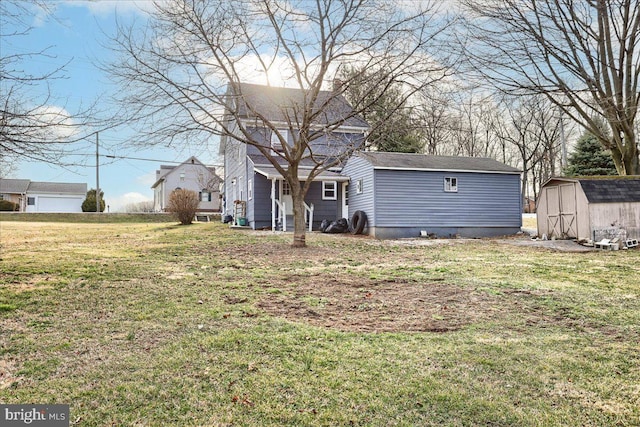 rear view of house with an outbuilding, a storage unit, and a yard