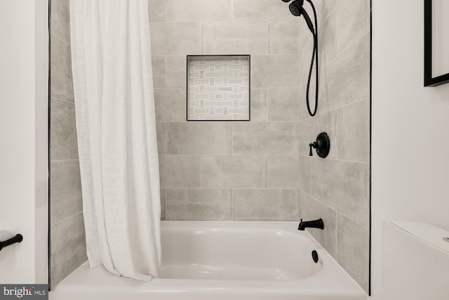 bathroom with shower / bathtub combination with curtain and toilet