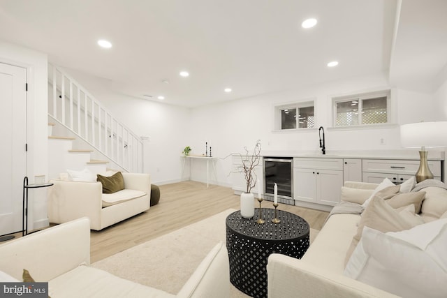 living area featuring wine cooler, recessed lighting, light wood-style flooring, and stairs