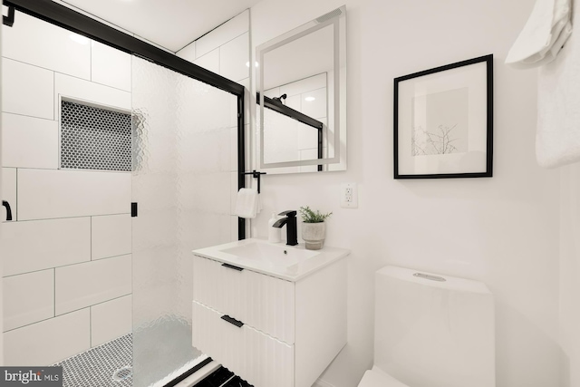 bathroom with a shower stall, toilet, and vanity