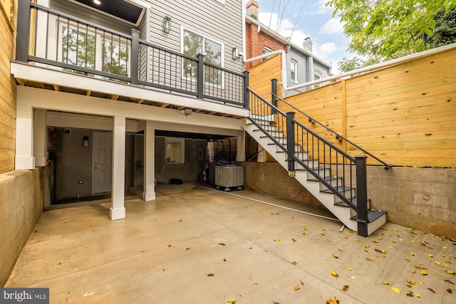 view of patio featuring stairway, an attached garage, central AC unit, and driveway