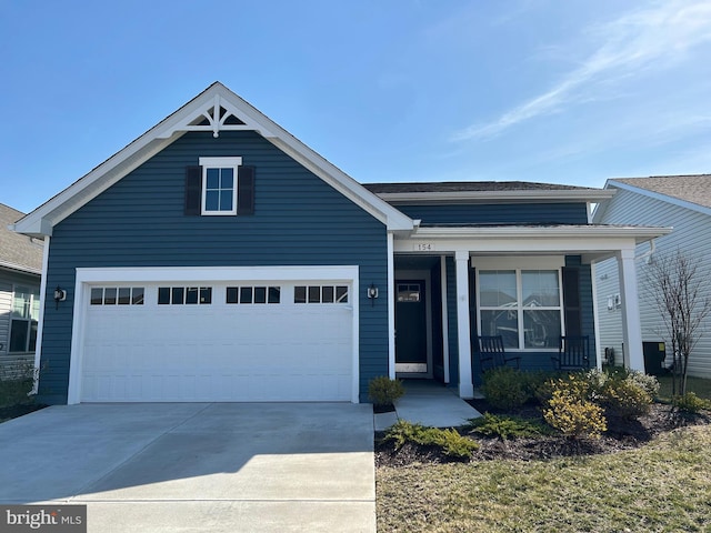 view of front of property featuring covered porch, concrete driveway, and a garage