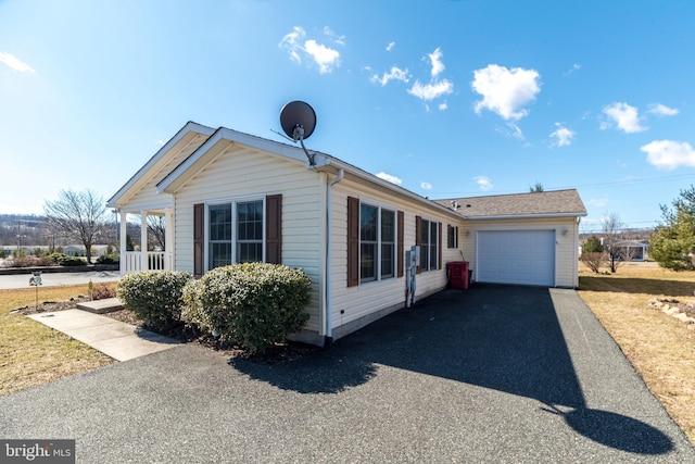 ranch-style home featuring a garage and aphalt driveway