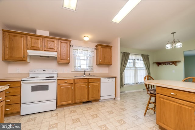 kitchen featuring under cabinet range hood, light countertops, brown cabinetry, white appliances, and a sink