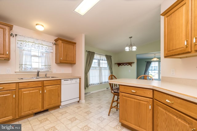 kitchen with a sink, visible vents, brown cabinets, and dishwasher