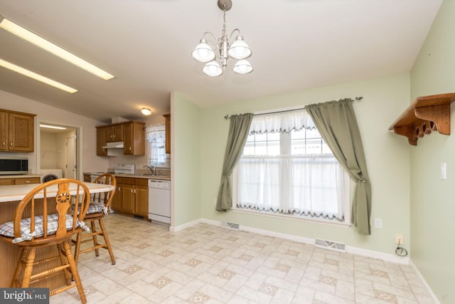 kitchen with white appliances, visible vents, light countertops, vaulted ceiling, and brown cabinets