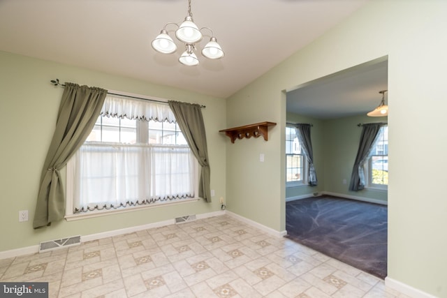 spare room with visible vents, plenty of natural light, and vaulted ceiling