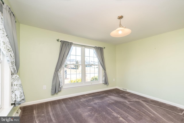 spare room featuring visible vents, carpet, and baseboards