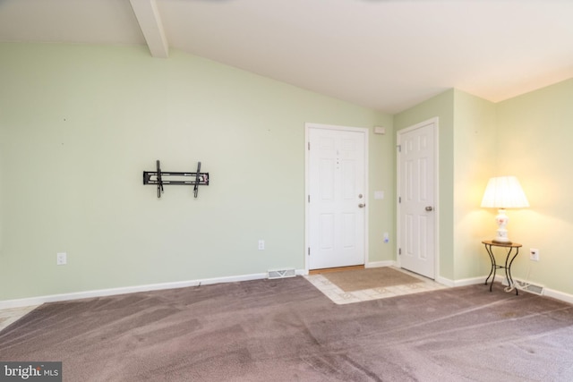 carpeted empty room featuring vaulted ceiling with beams, baseboards, and visible vents