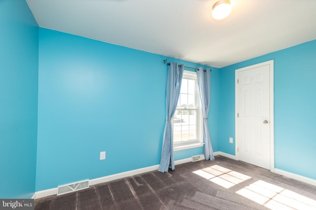 carpeted empty room featuring baseboards and visible vents