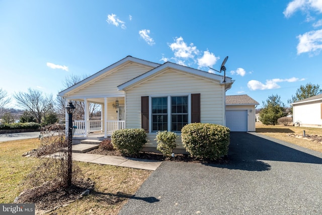 view of front of property with a garage, a porch, and driveway