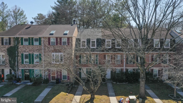 view of front of property featuring a front lawn and brick siding