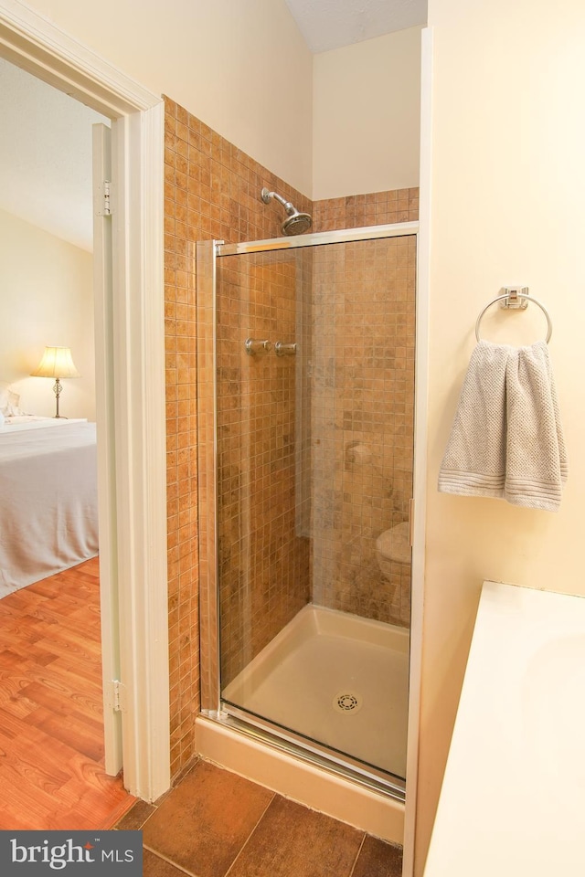 bathroom featuring connected bathroom and a shower stall