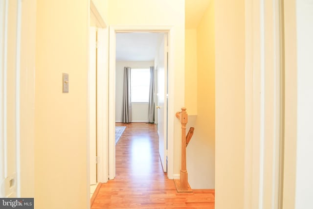 hall featuring an upstairs landing and light wood-style floors