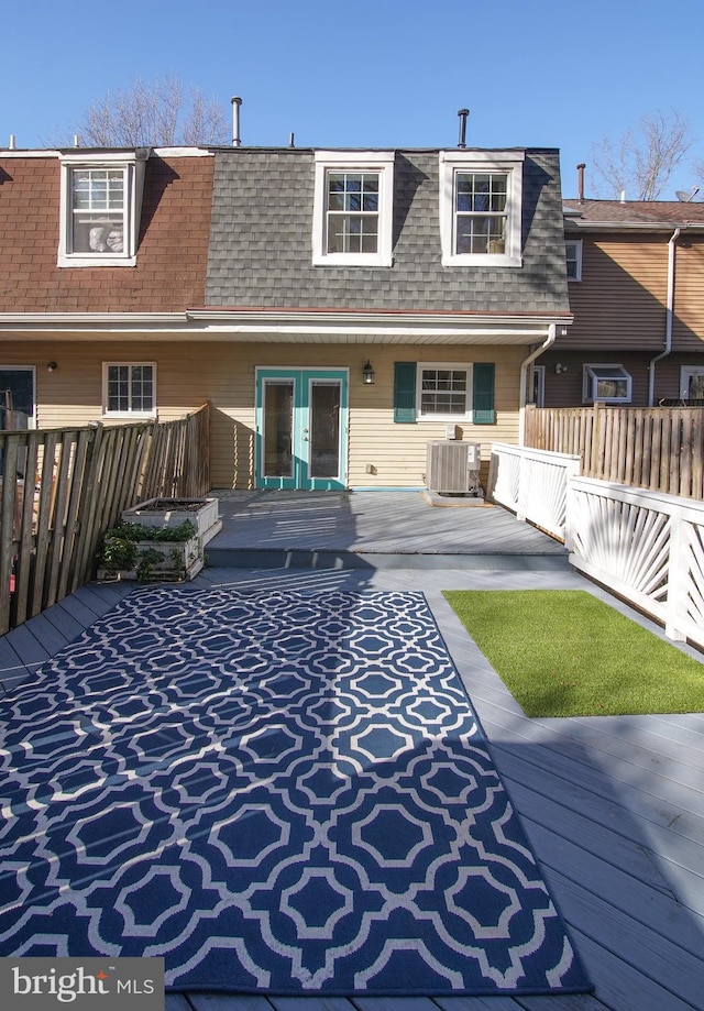 rear view of property with central AC, mansard roof, and roof with shingles