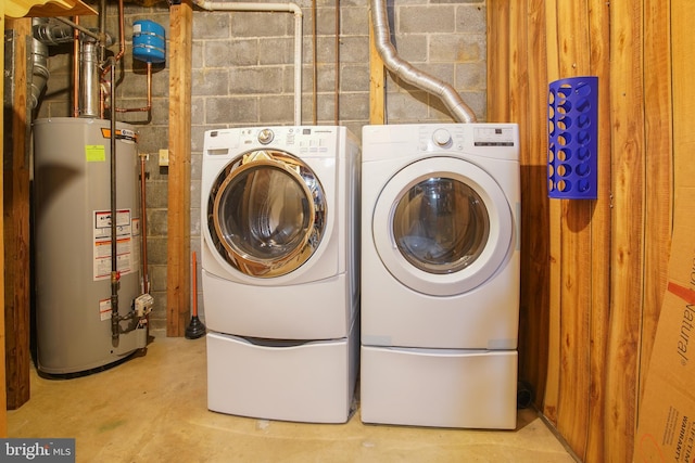 laundry area with water heater, laundry area, independent washer and dryer, and concrete block wall