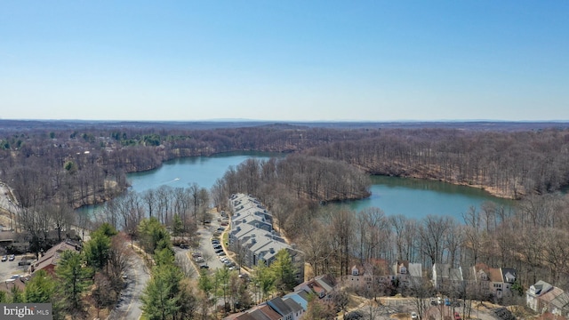 aerial view featuring a wooded view and a water view